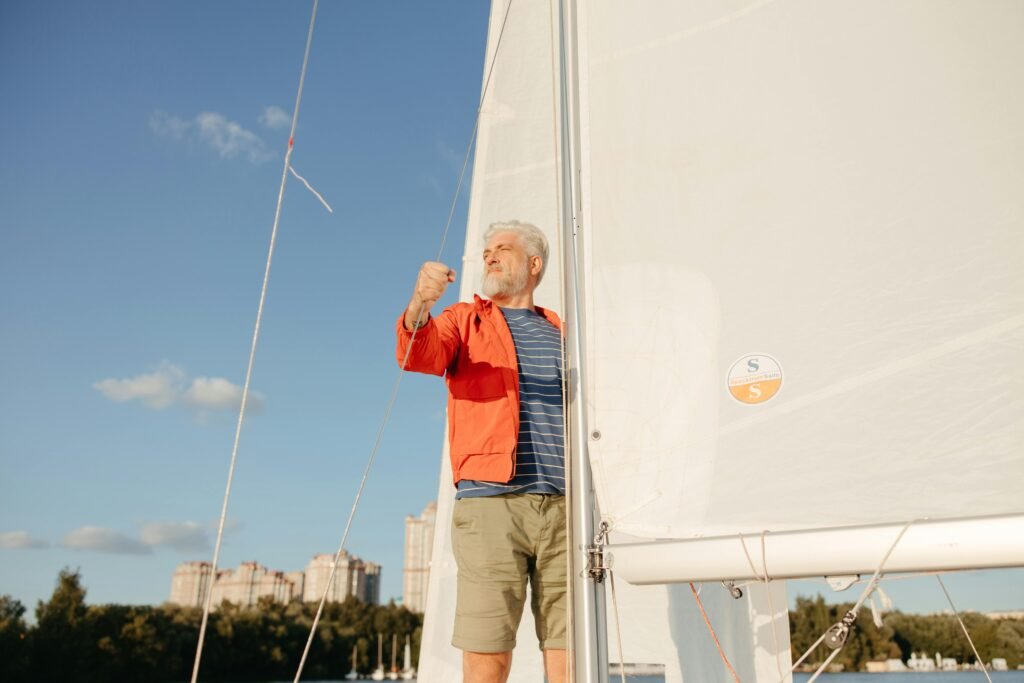 pexels-photo-8917028-8917028 A senior man confidently sailing, looking ahead under a clear blue sky.